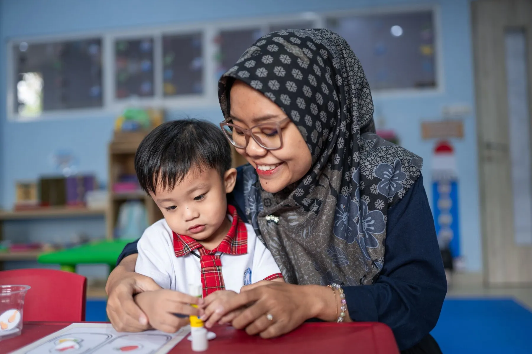 Guru membimbing siswa menulis