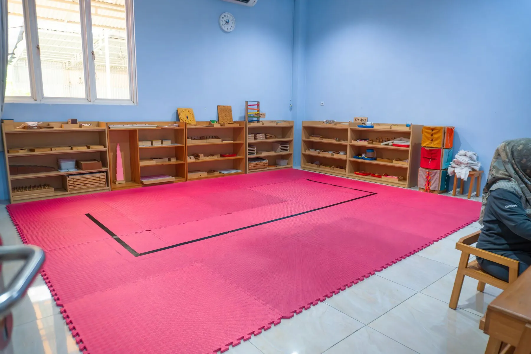 Ruang kelas berwarna dengan meja kecil dan papan tulis